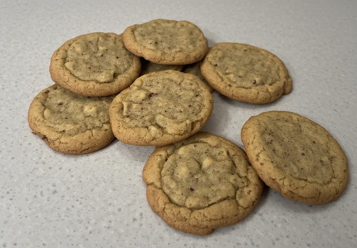 A cluster of approximately eight cookies is arranged on a speckled counter top.