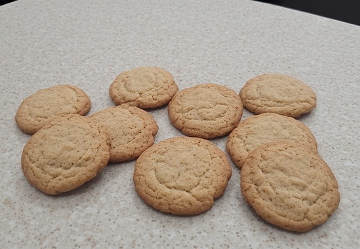Nine round sugar cookies is arranged on a speckled counter top