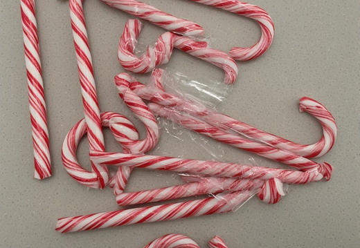 Candy canes scattered across a speckled gray surface