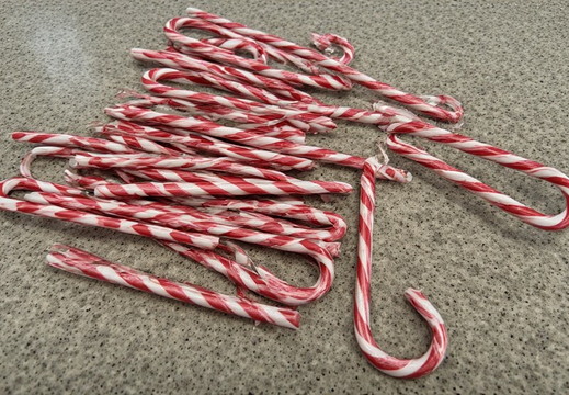 Candy canes scattered across a speckled gray surface