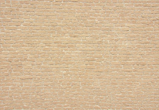 A full frame view of a brick wall constructed with sandy beige bricks