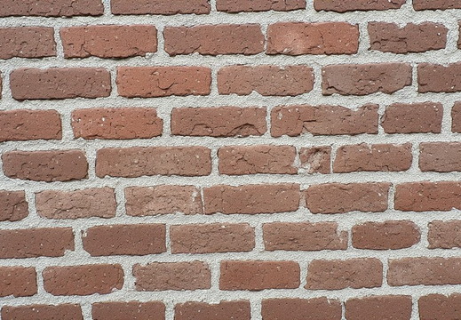 A brick wall that is arranged in a stretcher bond pattern.