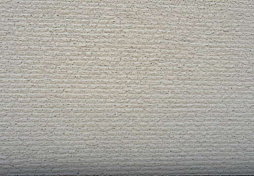 A brick wall made of light grey bricks.