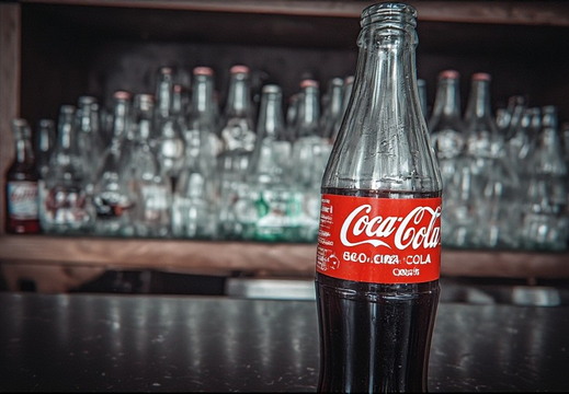 A close-up, eye-level shot of a glass Coca-Cola bottle