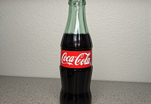 A full shot of a glass Coca-Cola bottle